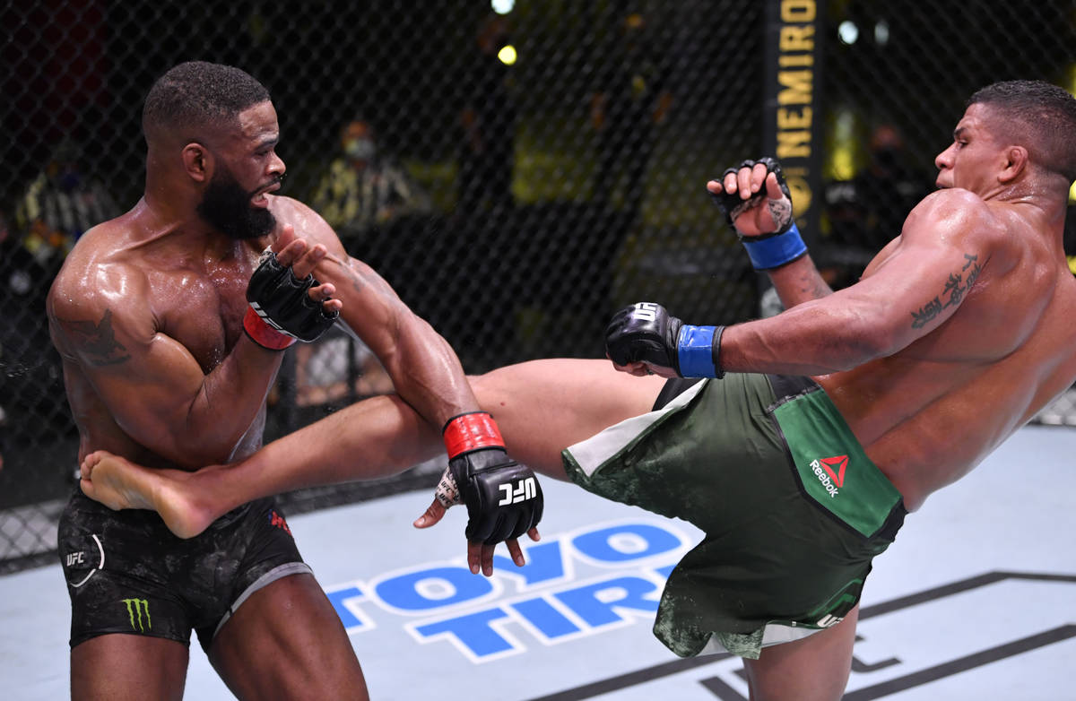 LAS VEGAS, NEVADA - MAY 30: (R-L) Gilbert Burns of Brazil kicks Tyron Woodley in their welterwe ...