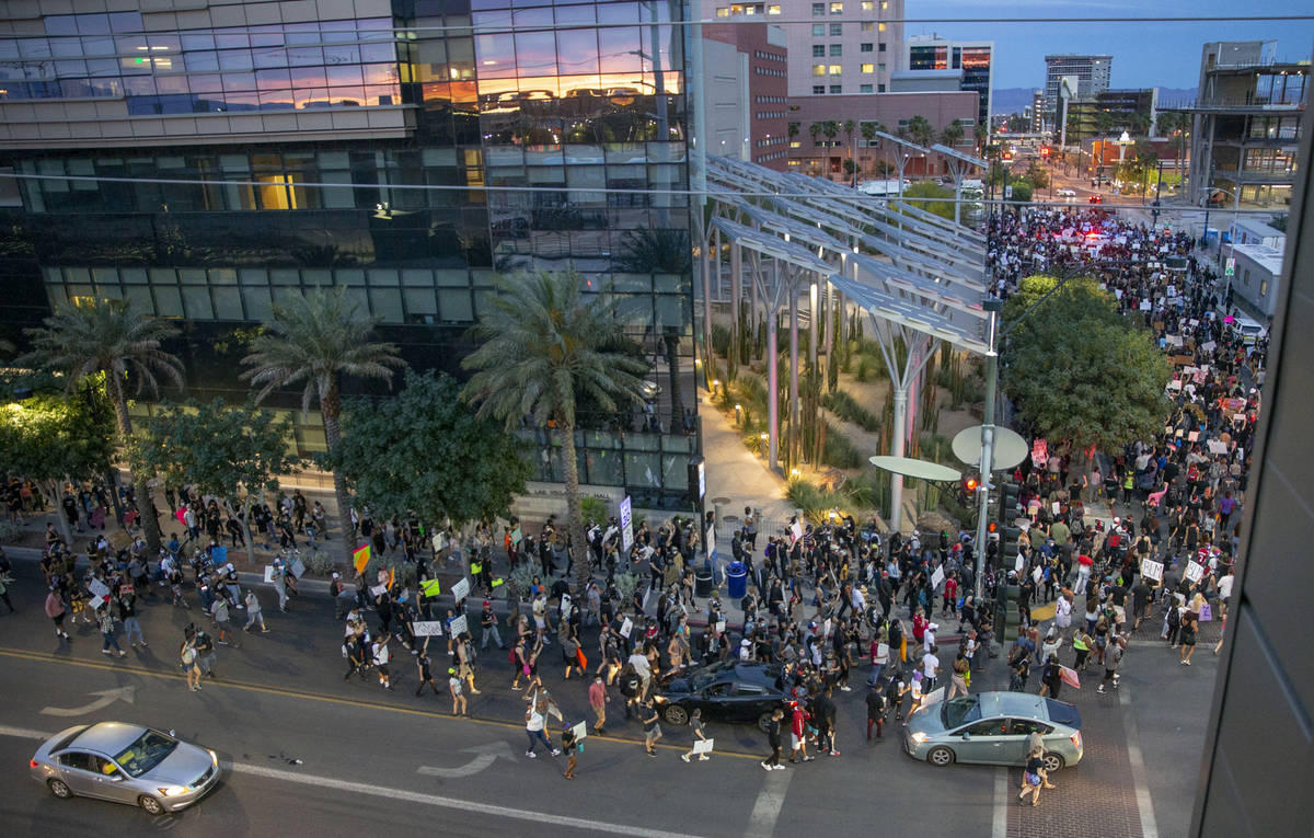 Protesters march past City Hall during a Black Lives Matter protest and march at Container Park ...