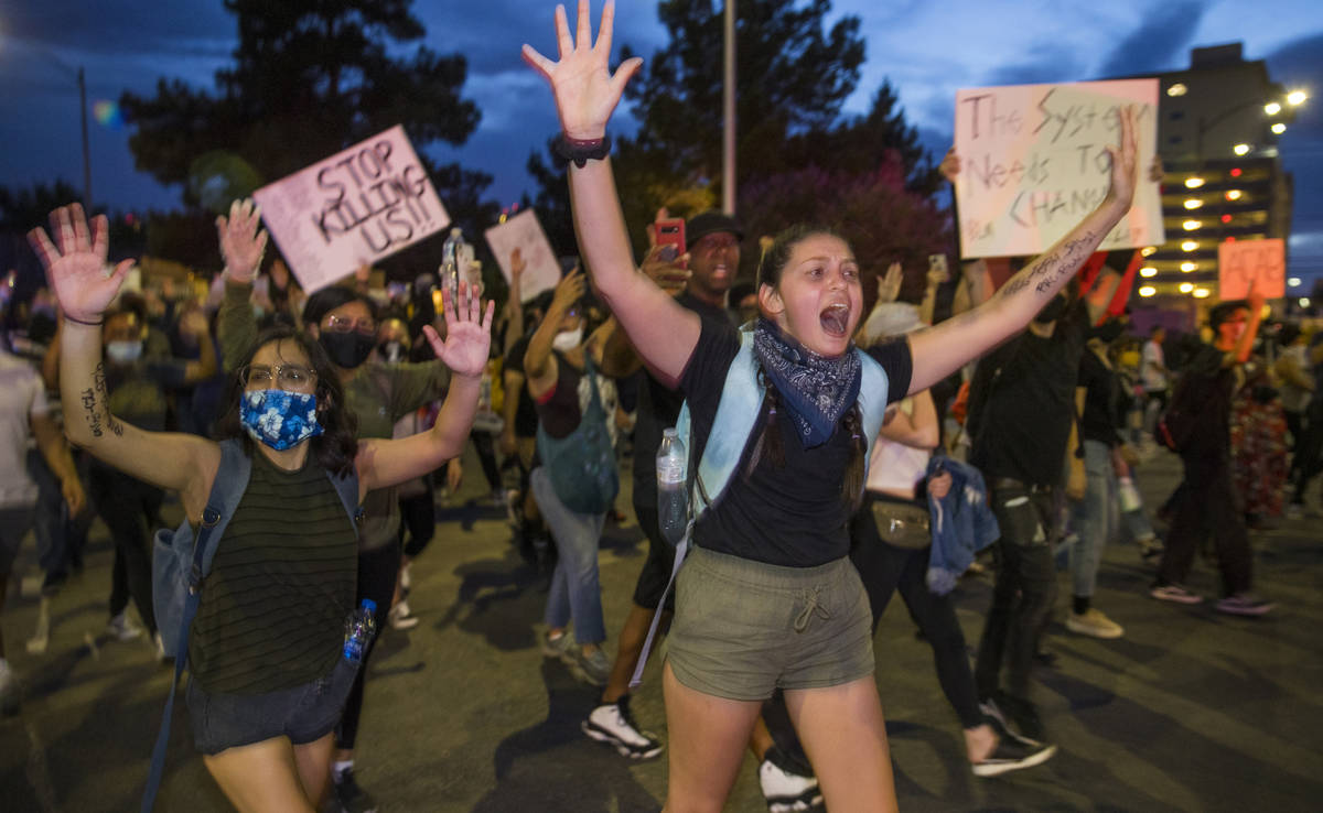 Protesters yell "Hands up, don't shoot" to police nearby as they march up 7th Street ...