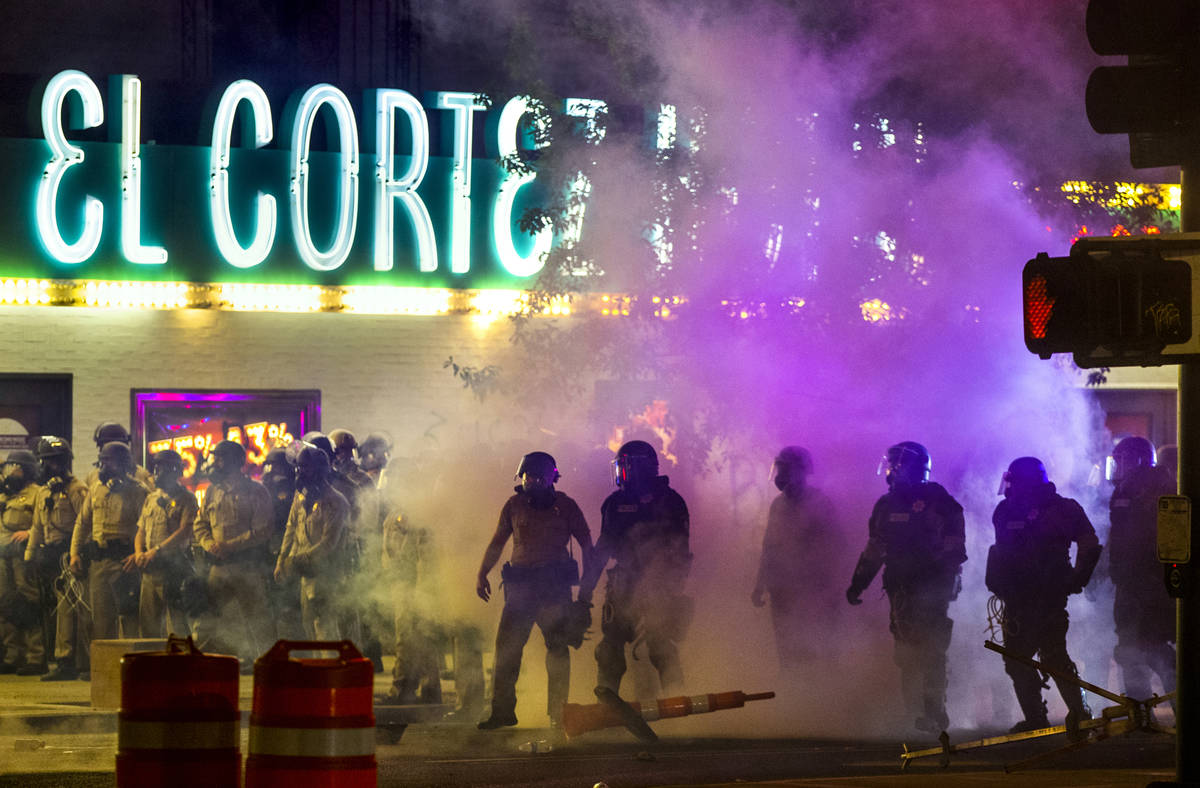 Las Vegas Police are engulfed in tear gas as protesters threw the canisters back on Fremont Str ...