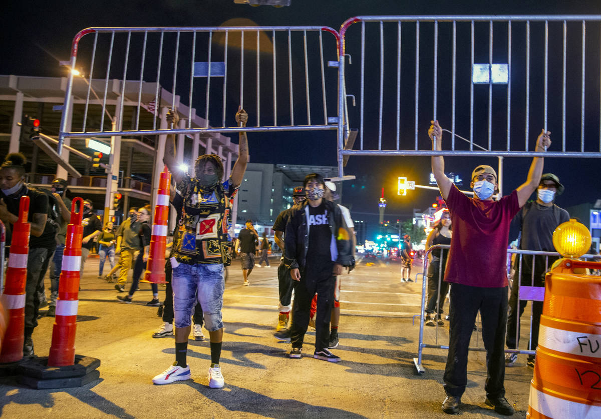 Protesters lift up barricades as they face off with Las Vegas Police on Las Vegas Blvd. as chao ...