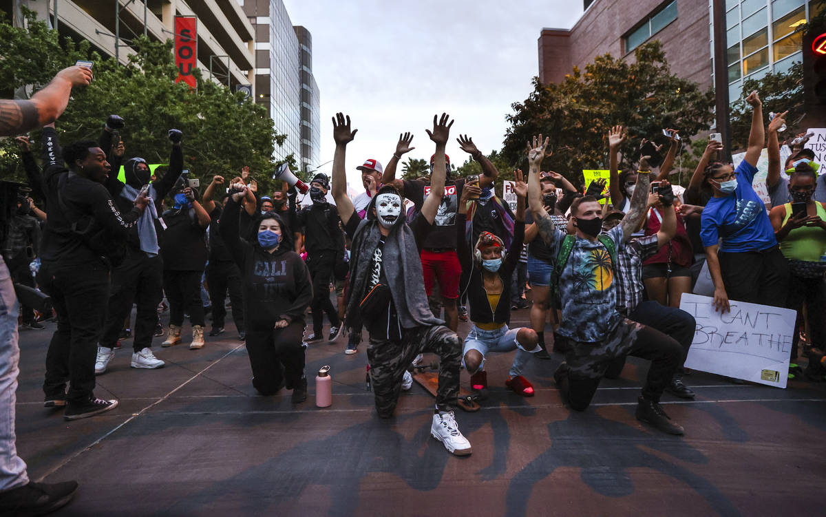 People kneel outside of the Clark County Detention Center while protesting the death of George ...