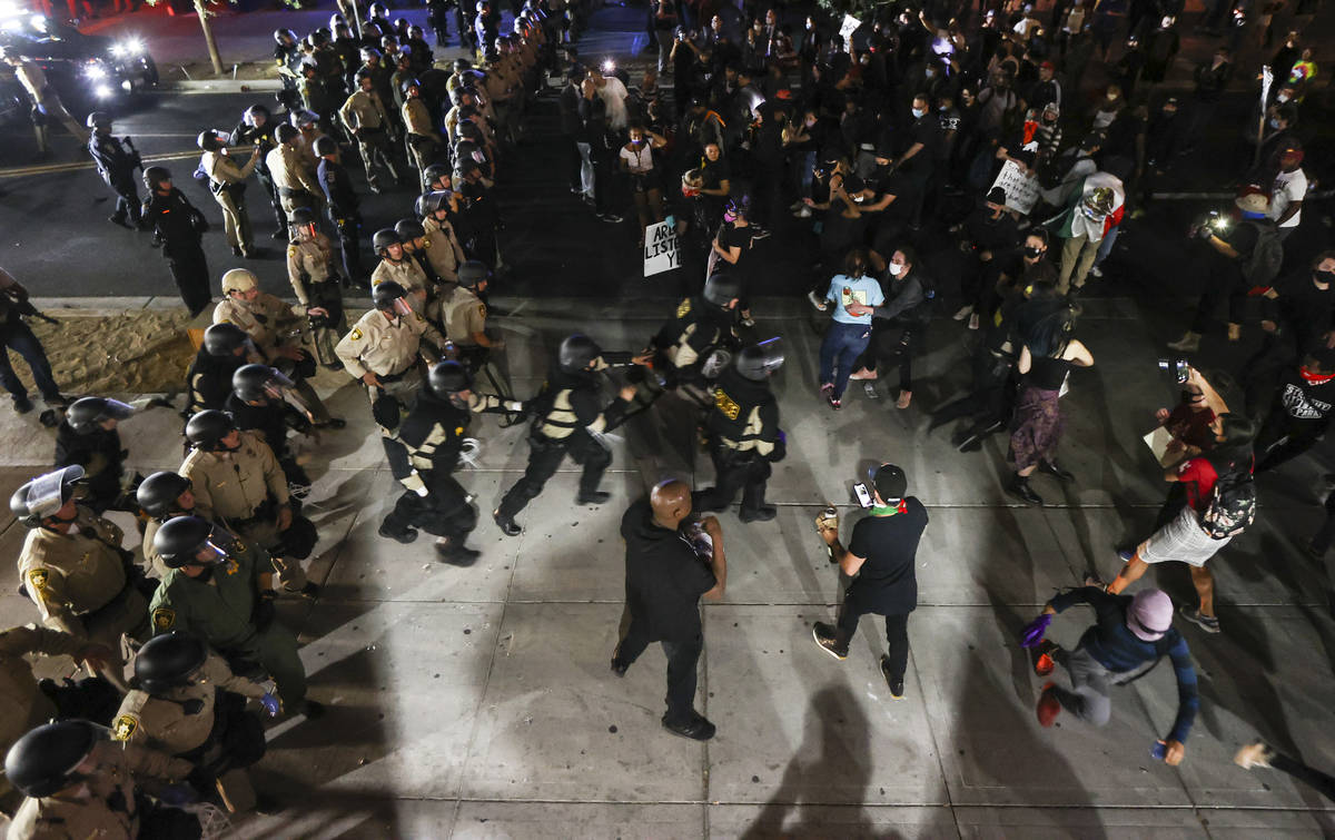 Police chase after a protester who appeared to throw a glass bottle while protesting the death ...