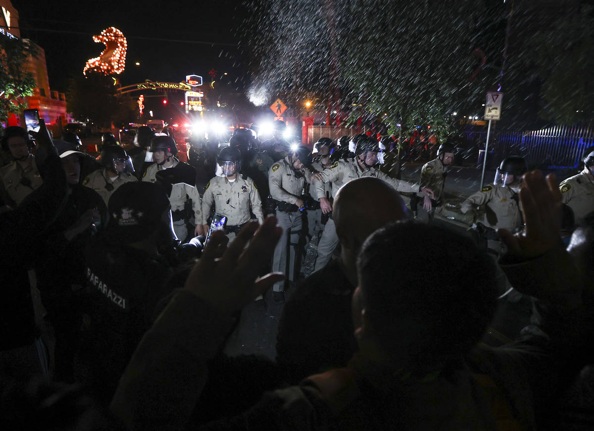 Water bottles are thrown at police officers as people protest the death of George Floyd in down ...