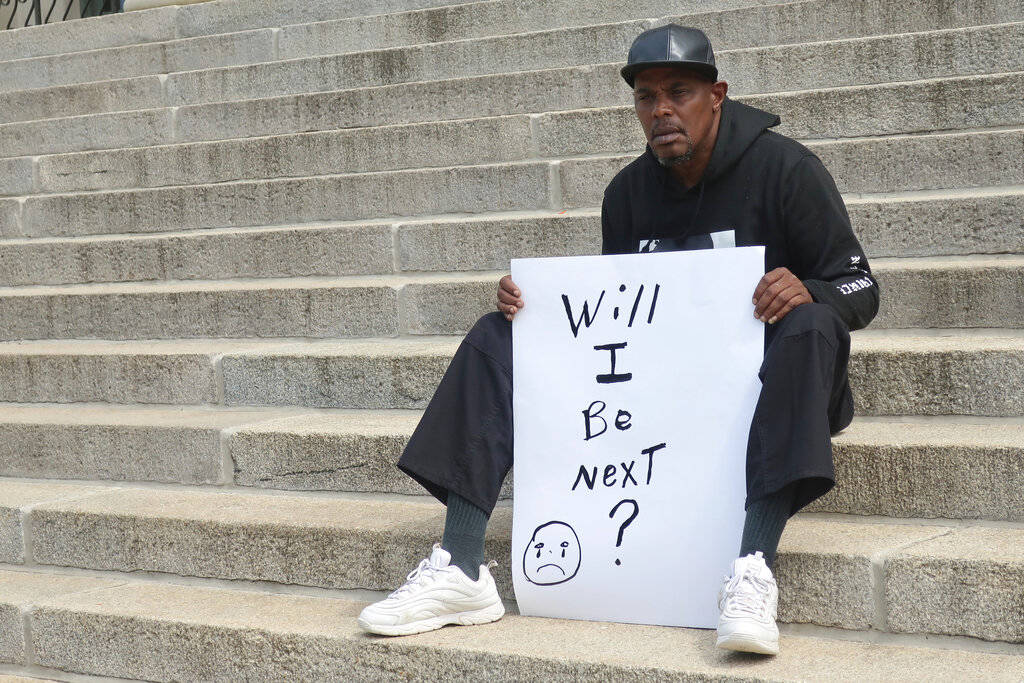 Jesse Spencer, 58, of Topeka, Kan., sits on the south steps of the Kansas Statehouse during a p ...
