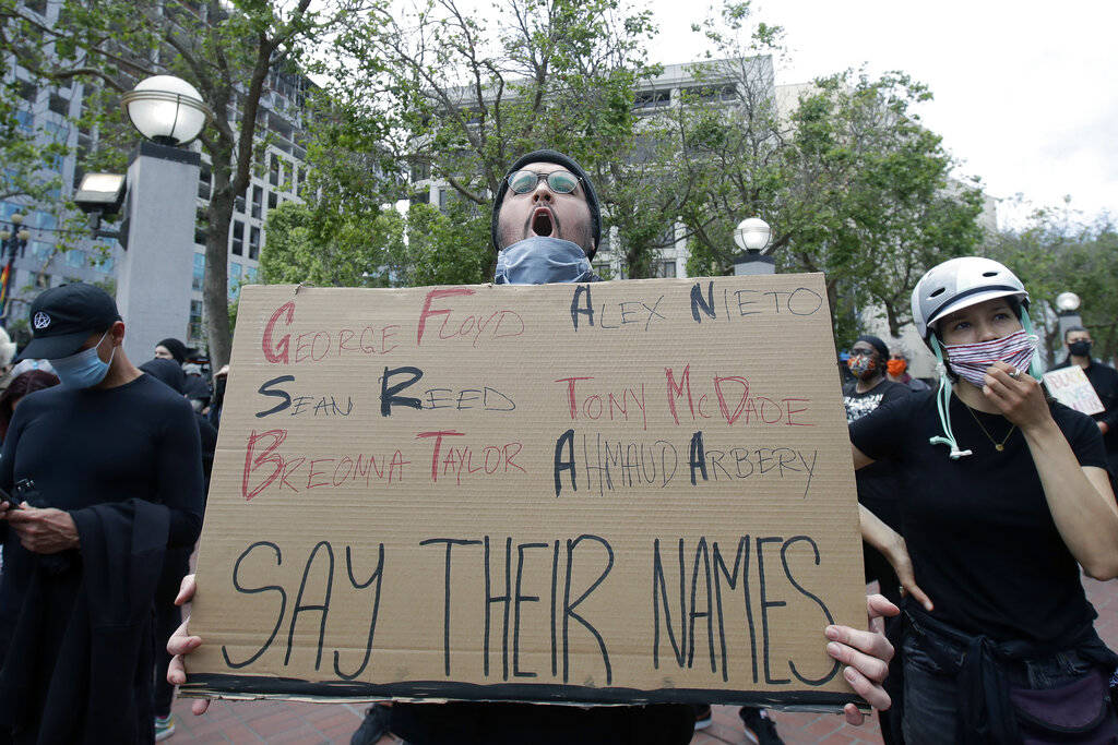 Nolan Ramirez holds up a sign at protest over the Memorial Day death of George Floyd, a handcuf ...