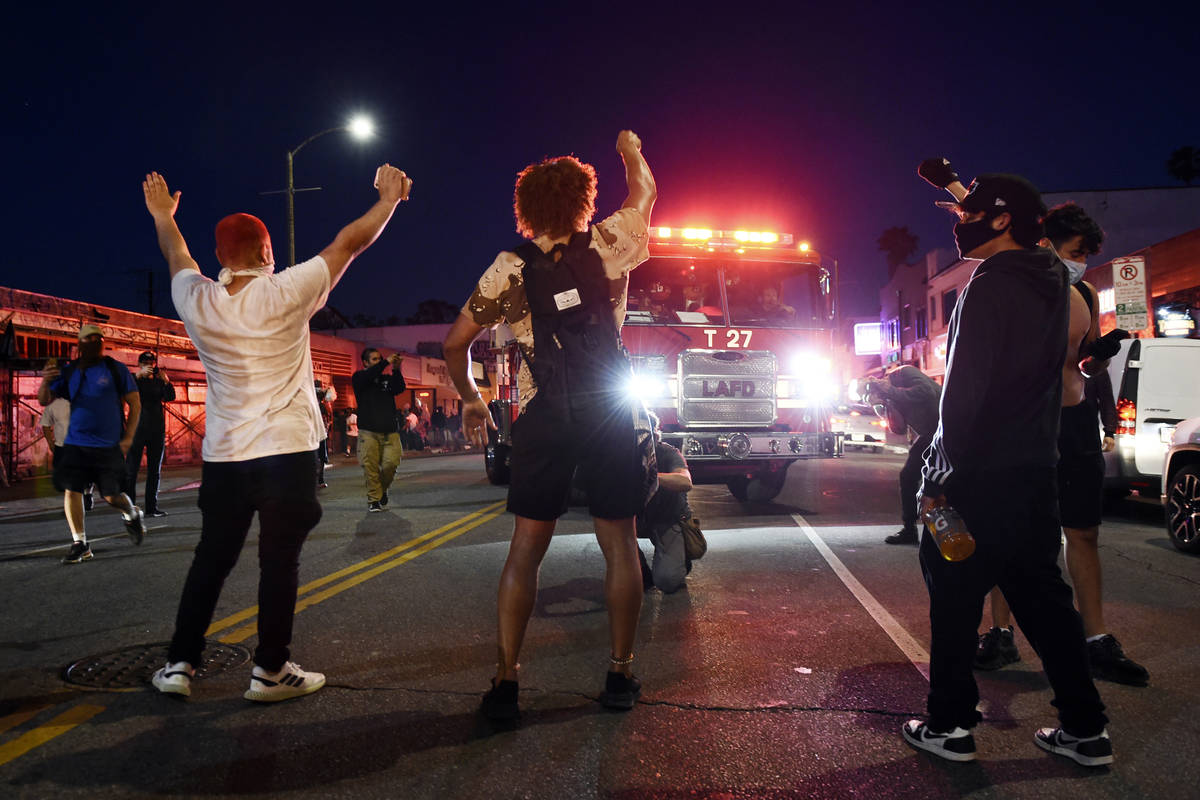 Demonstrators block the path of a Los Angeles Fire Department truck during a public disturbance ...