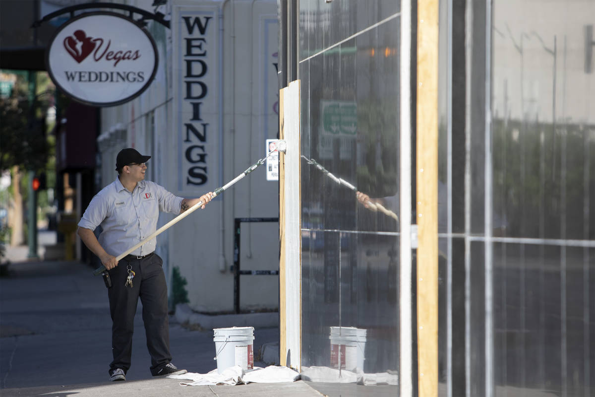 An employee from The D paints over graffiti leftover from the previous night's George Floyd pro ...
