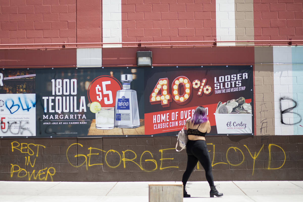 A woman photographs graffiti commemorating George Floyd, who was killed by Minneapolis police, ...