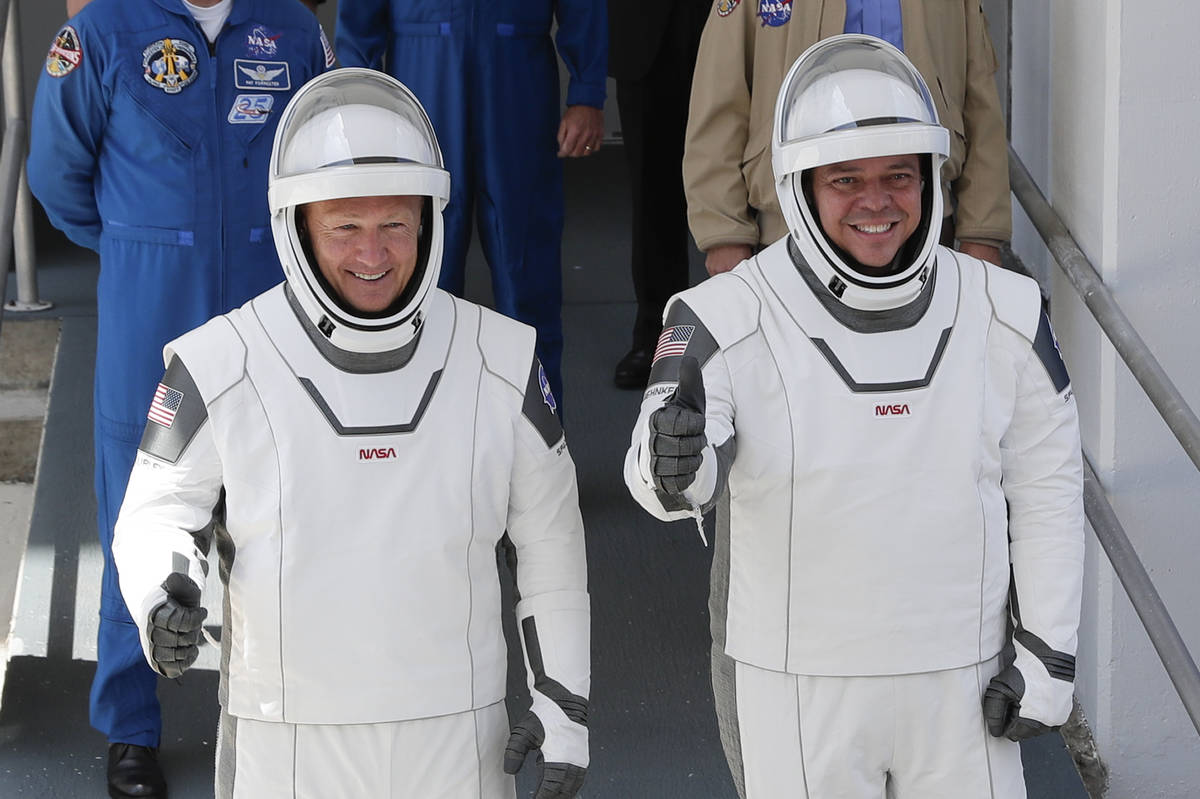NASA astronauts Douglas Hurley, left, and Robert Behnken walk out of the Neil A. Armstrong Oper ...