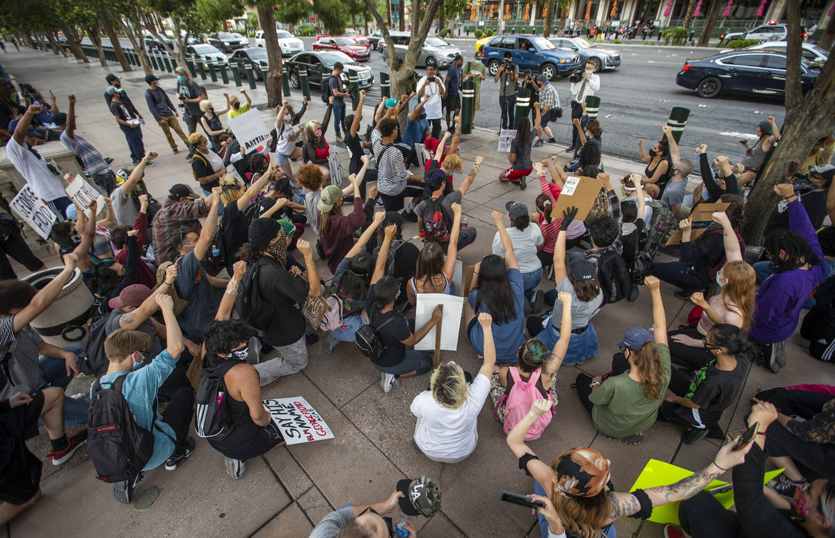 Protesters kneel and hold up fists in unity outside the Bellagio during a Black Lives Matter pr ...
