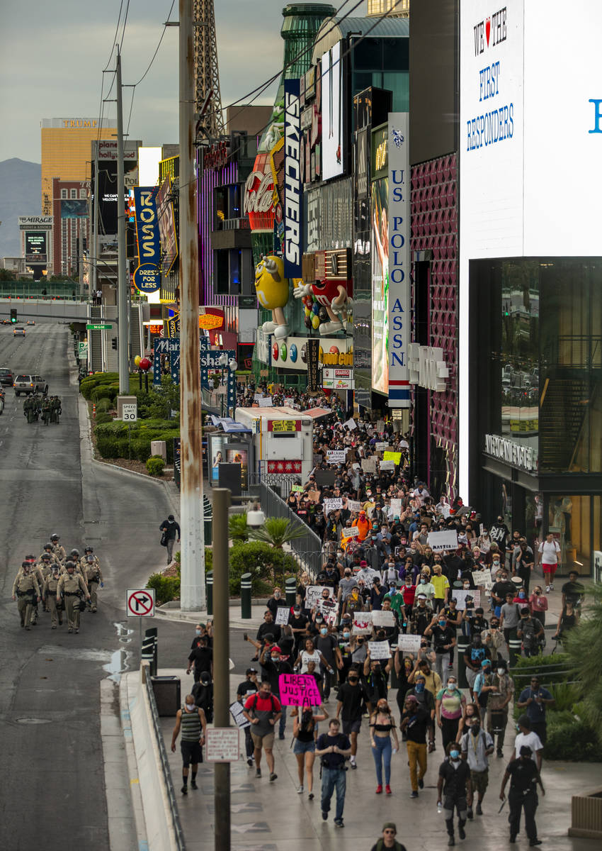 Las Vegas police officers and Black Lives Matter protesters walk along the Las Vegas Strip on S ...