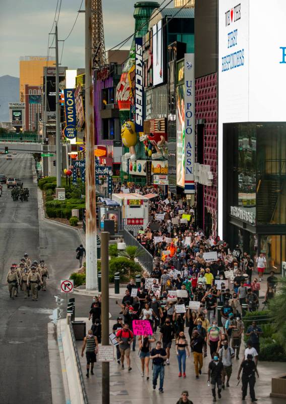 Las Vegas police officers and Black Lives Matter protesters walk along the Las Vegas Strip on S ...