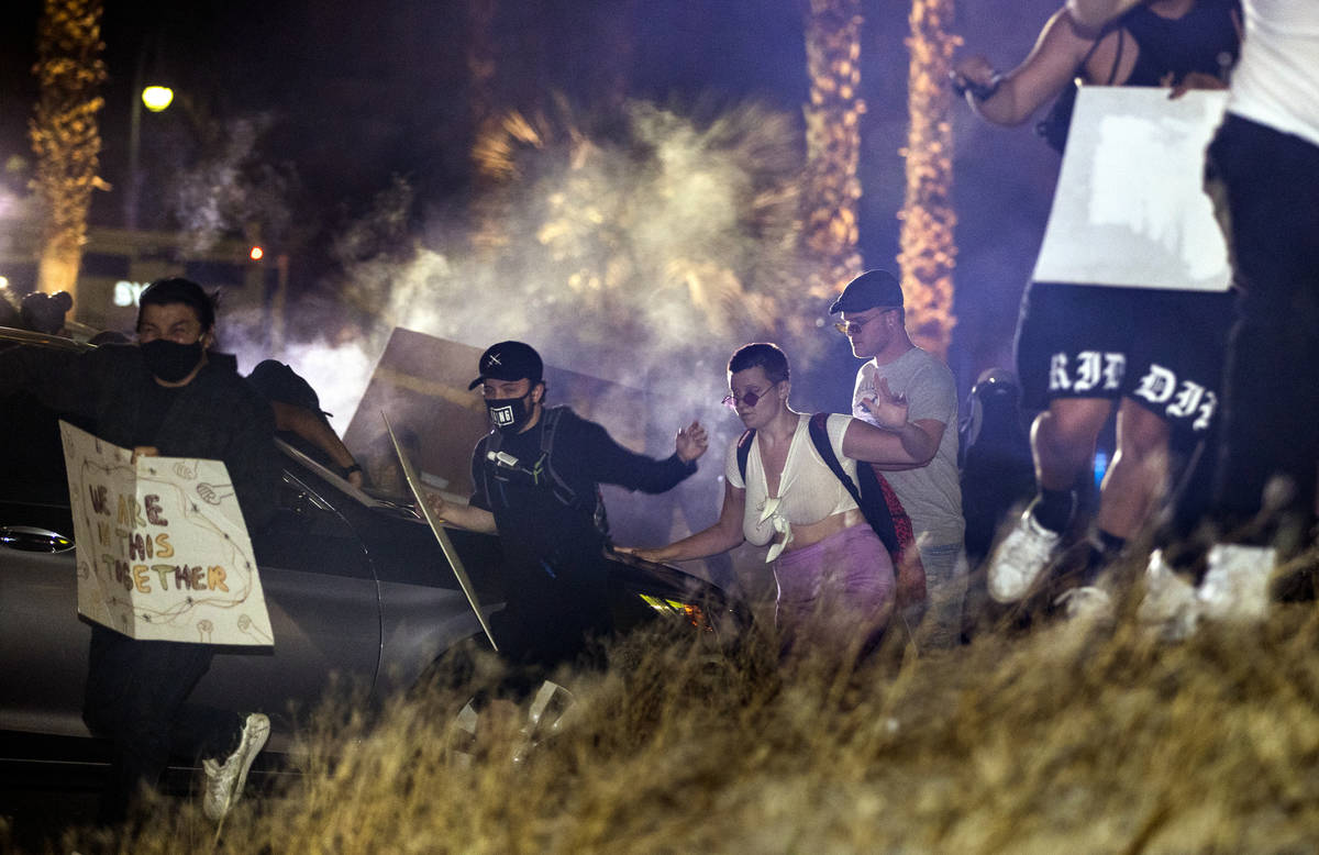 Protesters run after Las Vegas police fire tear gas and pepper bullets during a Black Lives Mat ...