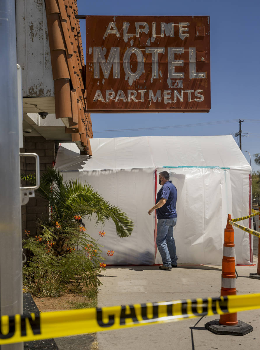 A crew leader from Earth Resource Group Environmental Services enters a white plastic tent cove ...