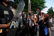 Demonstrators vent to police in riot gear as they protest the death of George Floyd, Saturday, ...