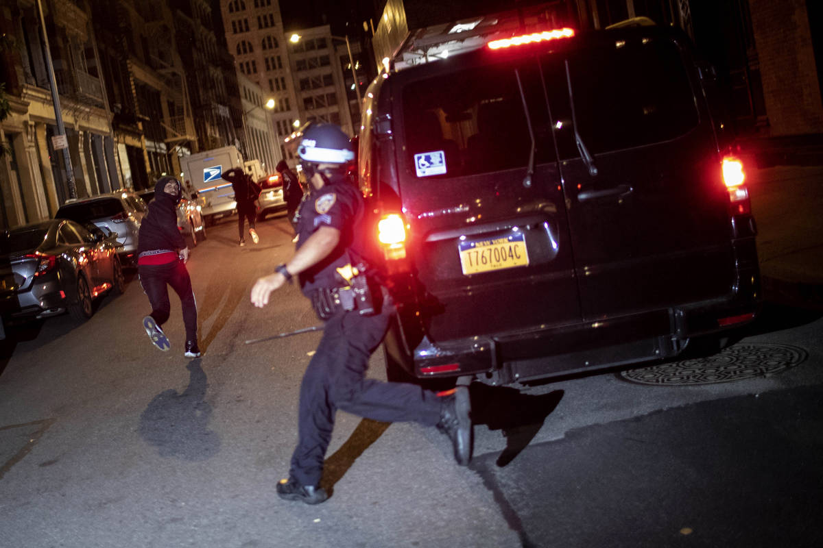 A protester runs as he is chased by police on Monday, June 1, 2020, in New York. Protests were ...
