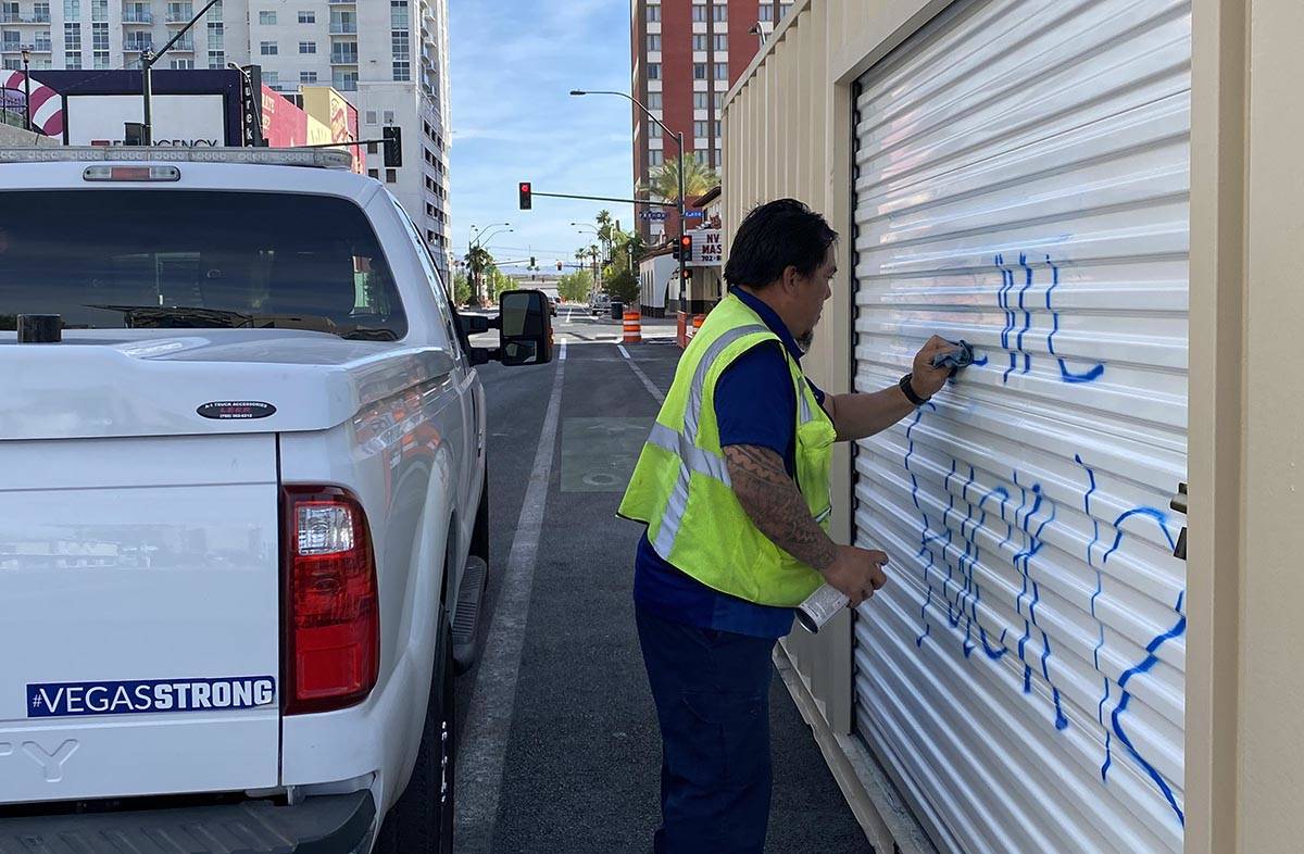 Workers were busy in downtown Las Vegas cleaning up graffiti and repairing damage caused by Sat ...