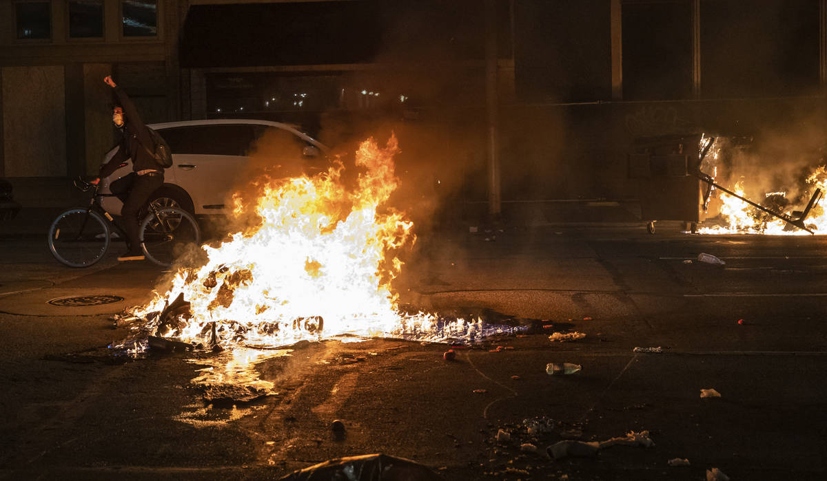 As night falls, protestors rally in downtown Indianapolis on Saturday, May 30, 2020. Protests w ...