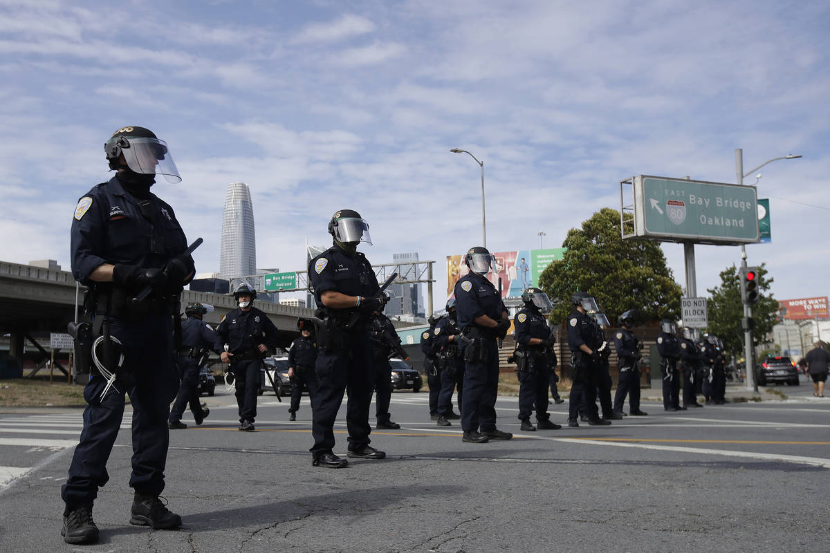 Police officers block a street near the San Francisco-Oakland Bay Bridge in San Francisco, Sund ...