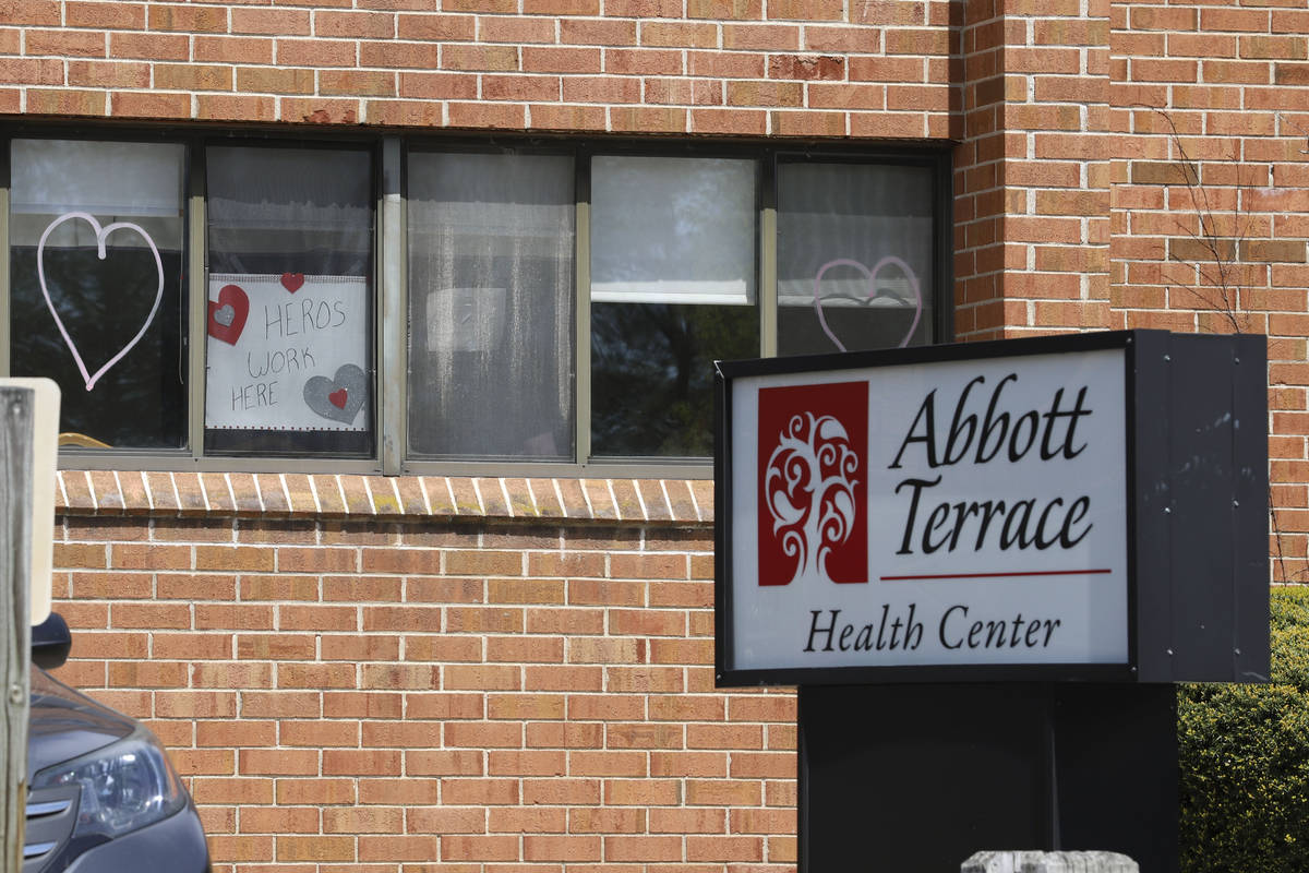 A sign for nursing home employees hangs in a window at the Abbott Terrace Health Center, Thursd ...