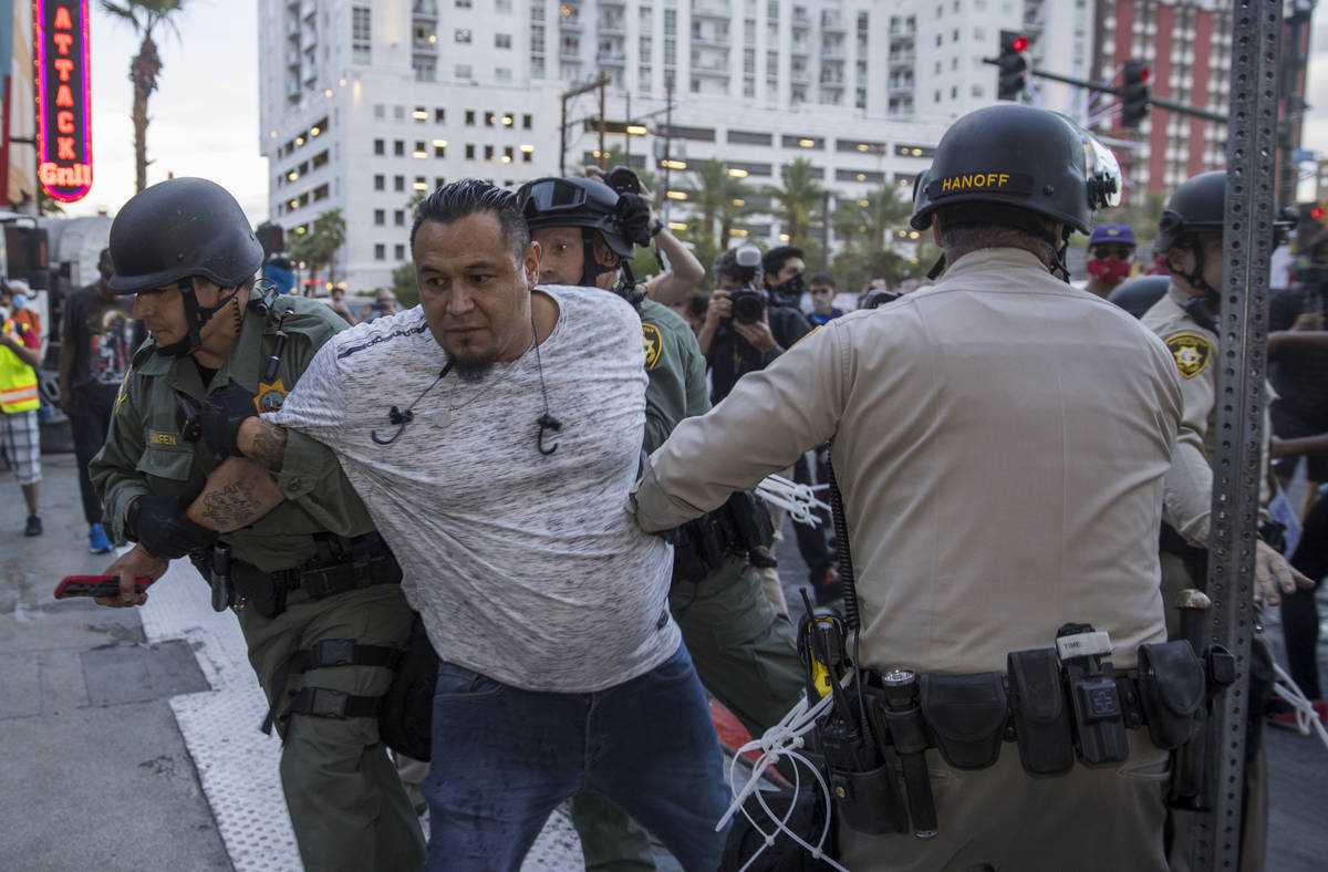 Police arrest a man confronting others at Fremont Street Experience during a Black Lives Matter ...