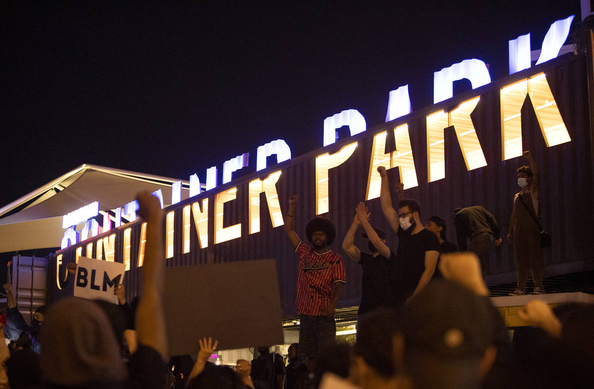 Black Lives Matter protesters take a knee and shout for George Floyd in Downtown Container Park ...