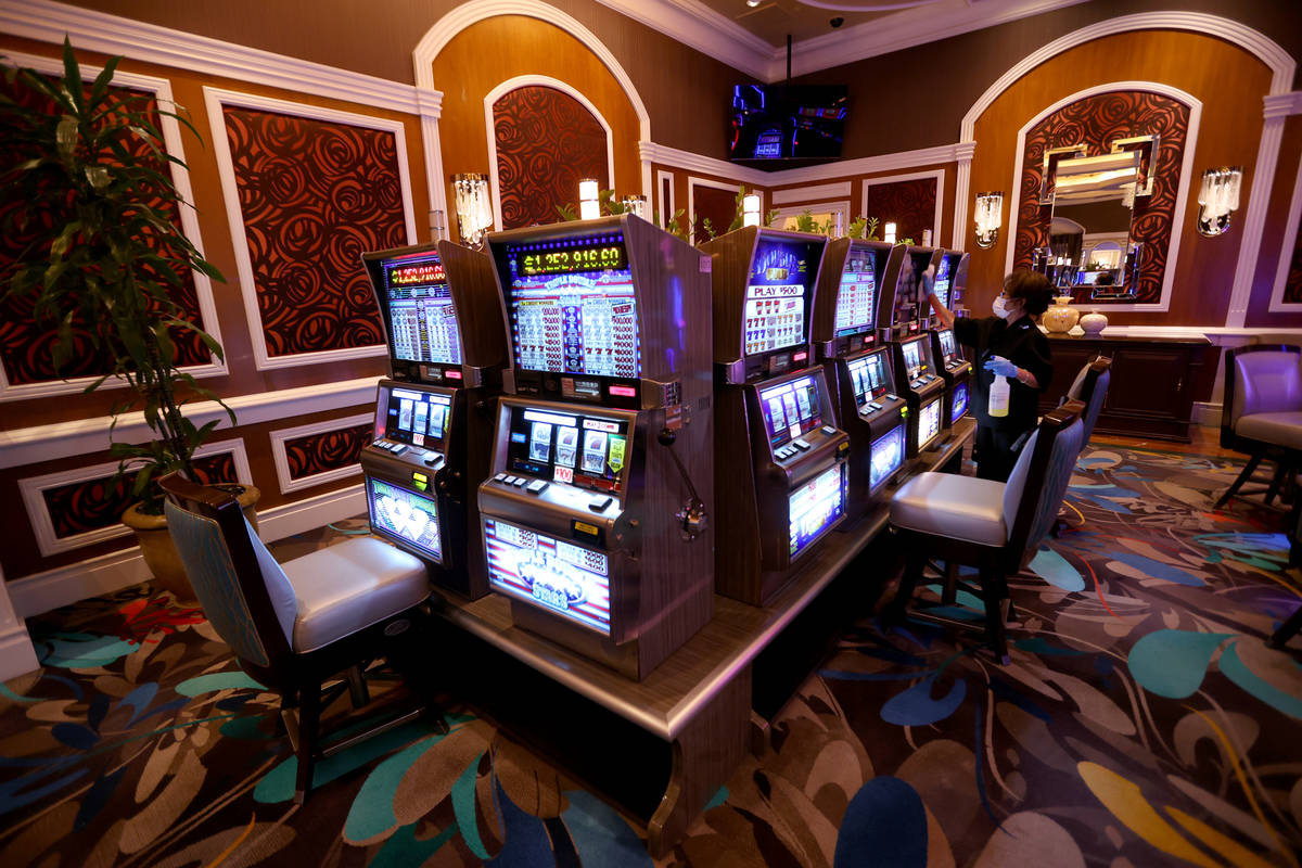 A worker cleans slot machines in the high limit room during a Bellagio media a tour showing &qu ...