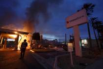 A man looks on as a bank burns after a protest over the death of George Floyd. (AP Photo/Gregor ...