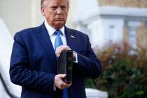 President Donald Trump holds a Bible as he visits outside St. John's Church across Lafayette Pa ...