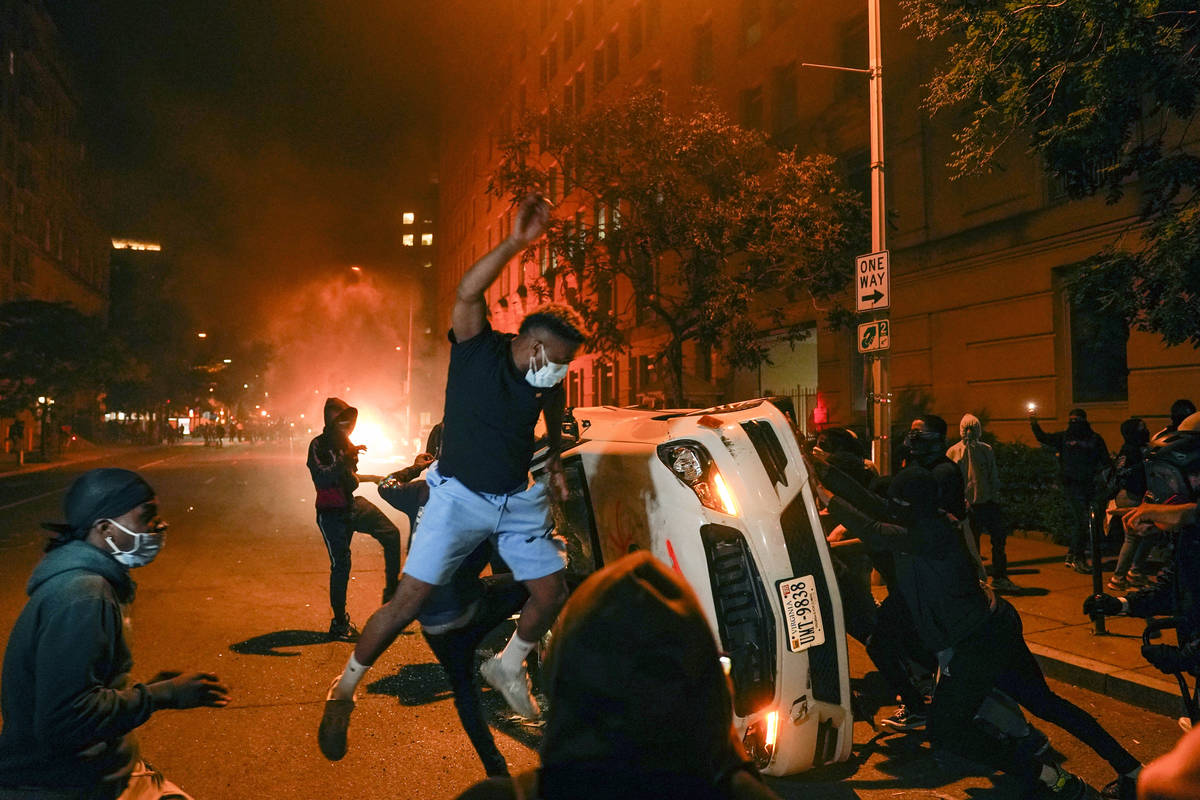 Demonstrators vandalize a car as they protest the death of George Floyd, Sunday, May 31, 2020, ...