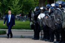 President Donald Trump walks past police in Lafayette Park after he visited outside St. John's ...