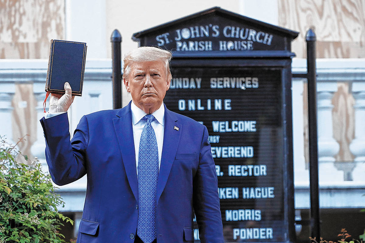 President Donald Trump holds a Bible as he visits outside St. John's Church across Lafayette Pa ...