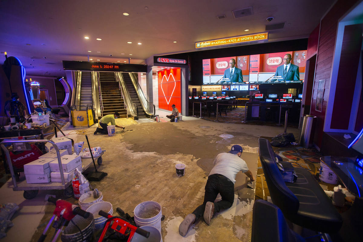 A construction crew lays down new flooring at TI during the closure due to the coronavirus pand ...