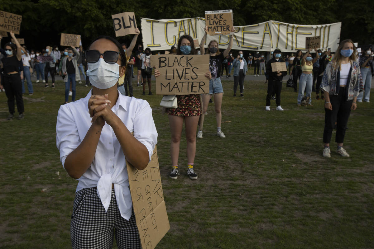 People observe social distancing as they take part in a demonstration in The Hague, Netherlands ...