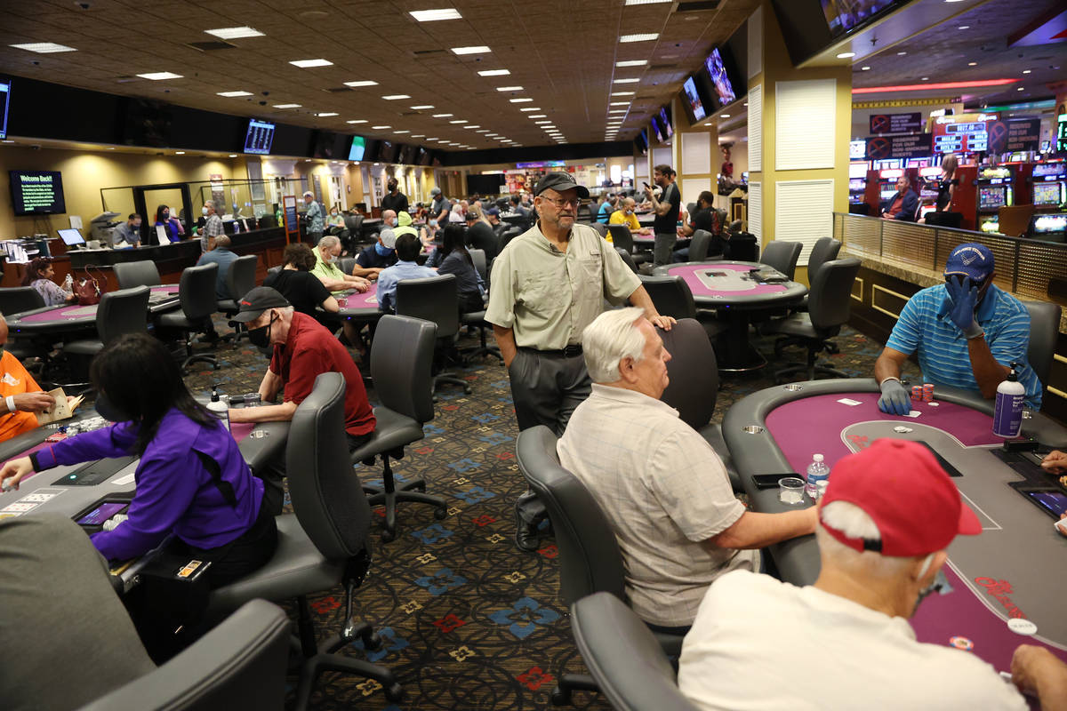 People play poker during the first day of reopening at The Orleans hotel-casino in Las Vegas, T ...