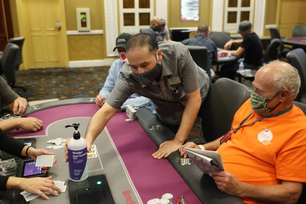 Manajer shift poker, Kenneth Davis mengantarkan sebotol pembersih Gand baru ke meja di ...