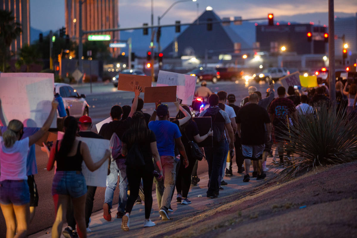 Protesters march with the Strip in the distance during a Black Lives Matter protest at UNLV in ...