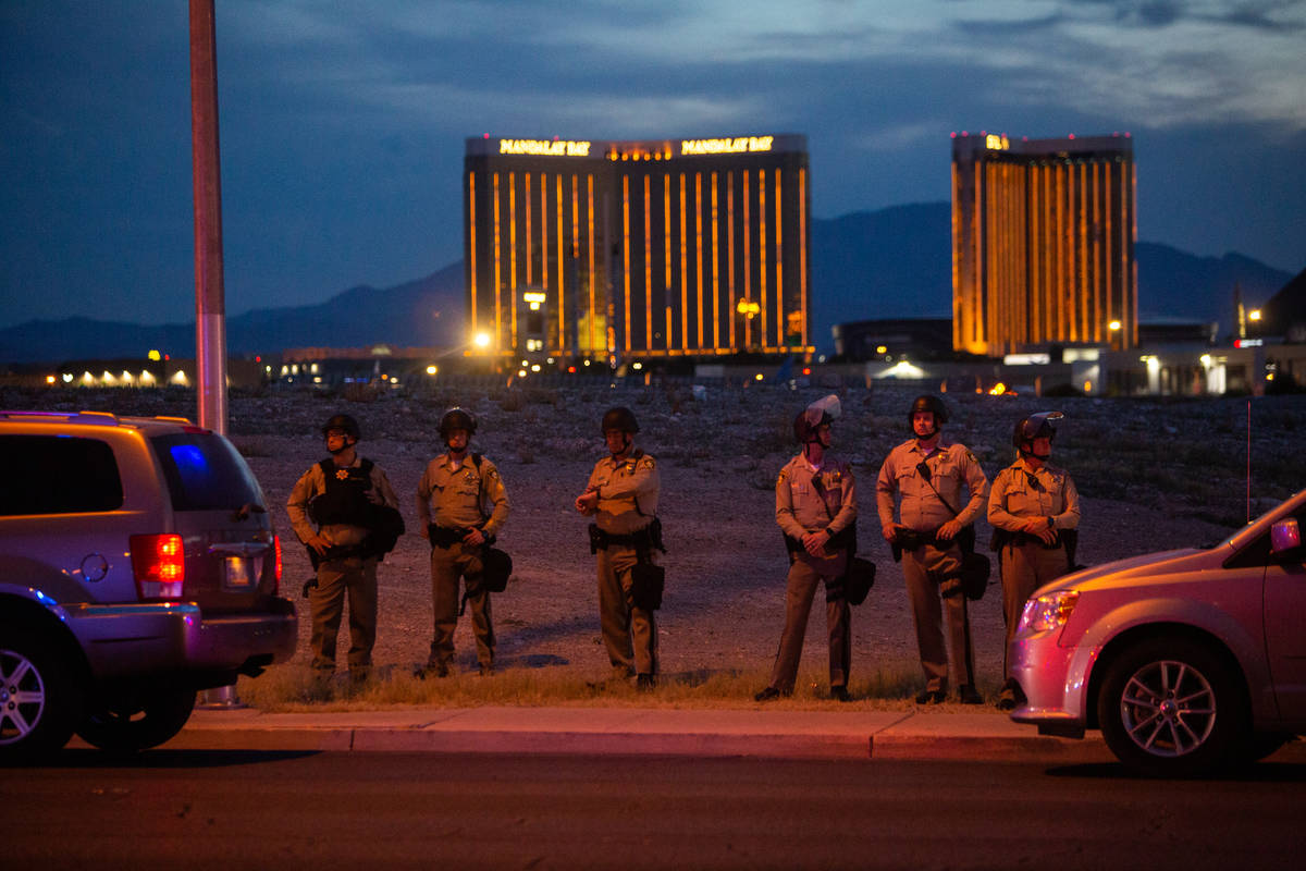 Las Vegas police watch protesters march with the Strip in the distance during a Black Lives Mat ...