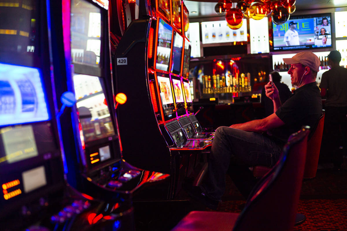 A man records while playing slots at the Golden Nugget as hotel-casinos  reopen in downtown Las … | Las Vegas Review-Journal