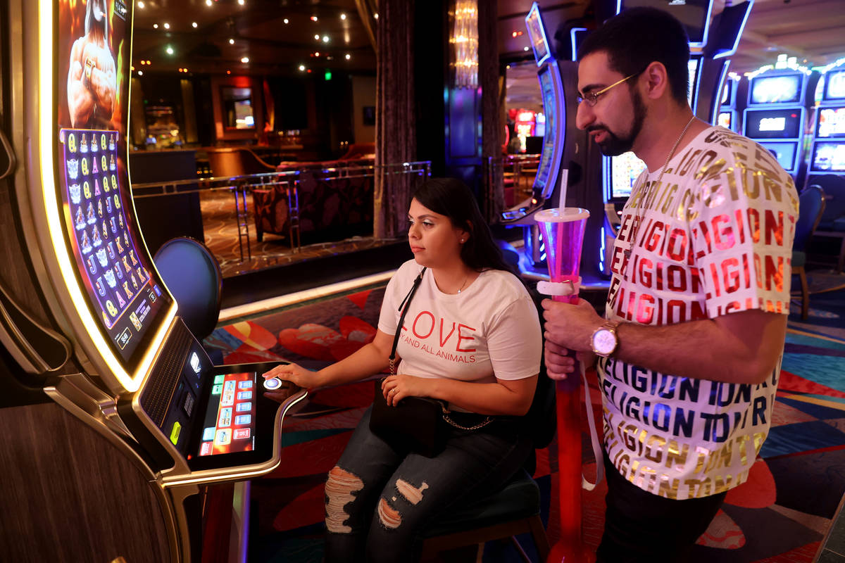 Arash Shahbazian and Michelle Muniz of Los Angeles play a slot machine at the Bellagio on the S ...