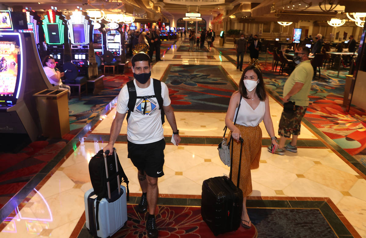 Jorge Aith and his wife Tassia Reis from Brazil head to their room at the Bellagio on the Strip ...