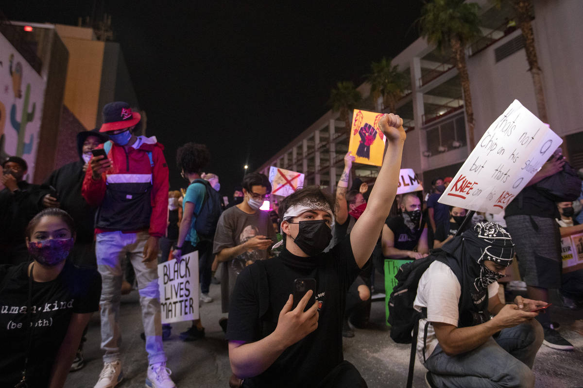 Protesters for George Floyd and against police brutality face police in a peaceful demonstratio ...
