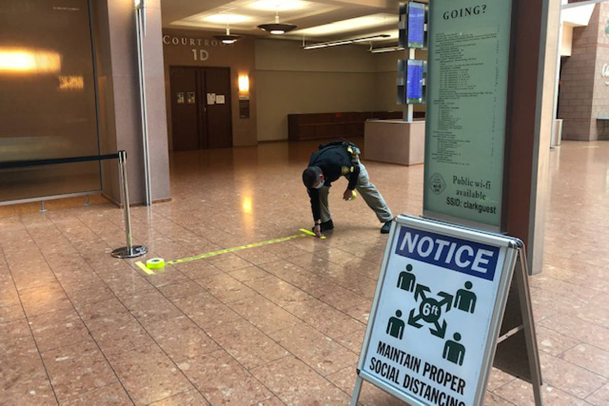 A marshal lays tape along the first floor of the Regional Justice Center on Friday, May 29, 202 ...