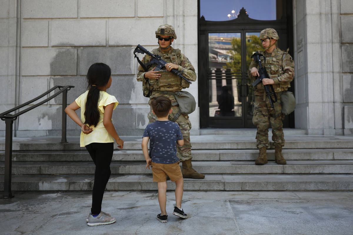 Bianca Luna, 6, left, and Elijah Ducey, 3, ask members of the California National Guard if they ...