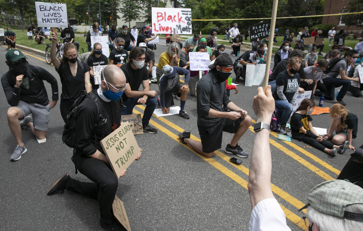 People including Kevin Antlitz, an Anglican priest, left, take a knee during a protest of the v ...