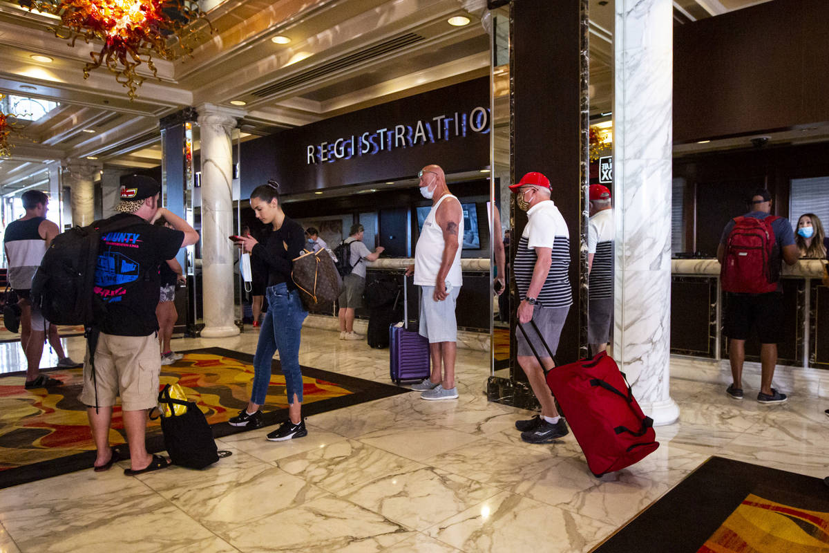 Guests line up while social distancing for check-in at the Golden Nugget in downtown Las Vegas ...