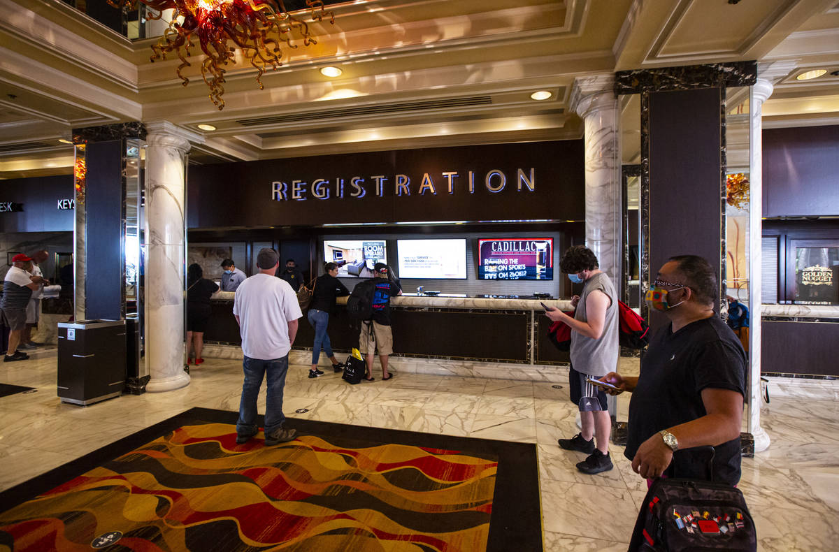 Guests line up while social distancing for check-in at the Golden Nugget in downtown Las Vegas ...