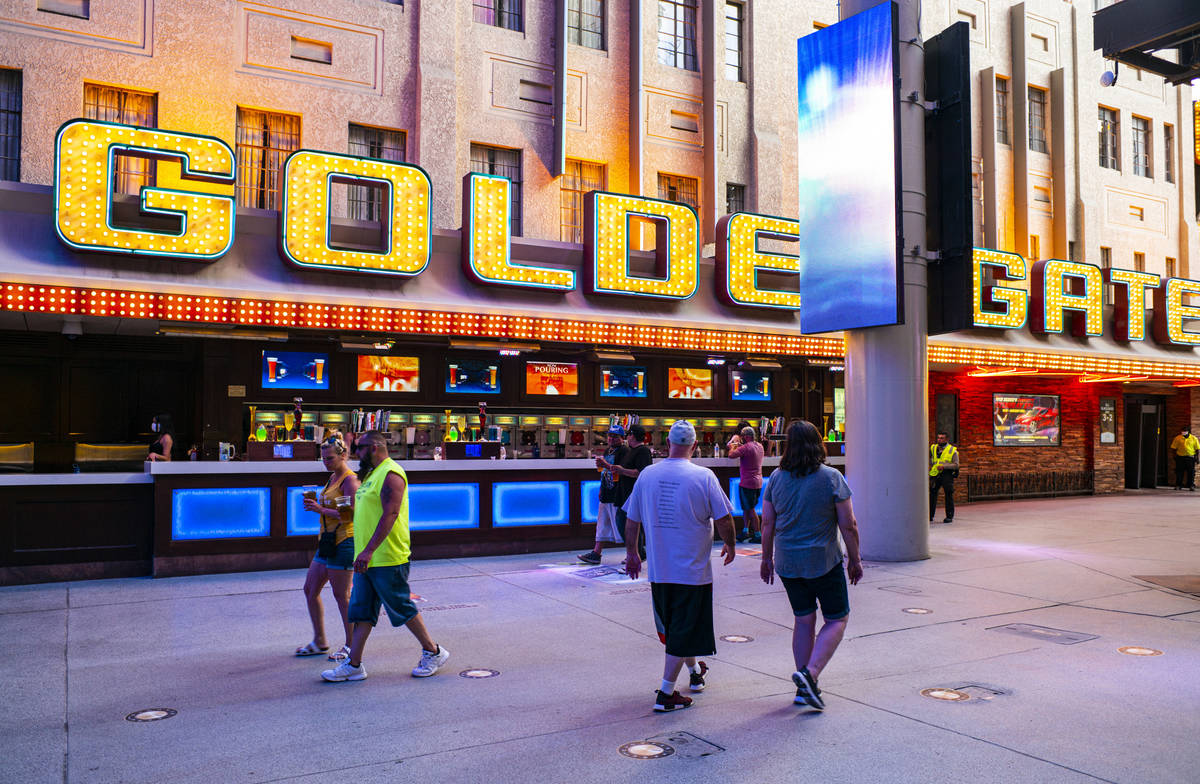 People walk around the Fremont Street Experience as hotel-casinos reopen in downtown Las Vegas ...