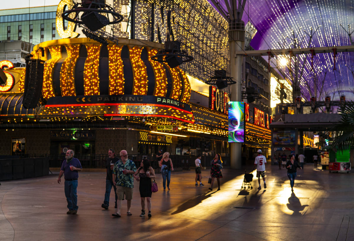 People walk around the Fremont Street Experience as hotel-casinos reopen in downtown Las Vegas ...